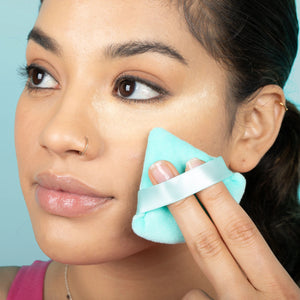 Person using a Freeman Mother Puffer Powder Puff on their cheek