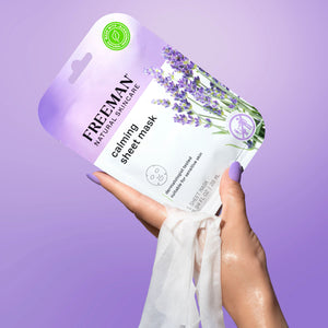 Hand holding Freeman calming sheet mask package with lavender flowers
