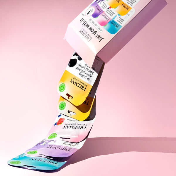 Stack of facial sheet and eye mask sachets in pastel colors, angled view.