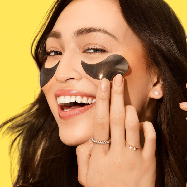 Hydrogel under-eye patches applied under eyes, two black crescent shapes