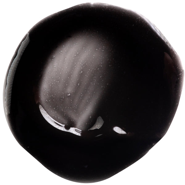 Black salt peel-off mask residue smear, glossy dark paste sample