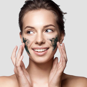 Woman with dark charcoal + black sugar gel mask covering cheeks and chin