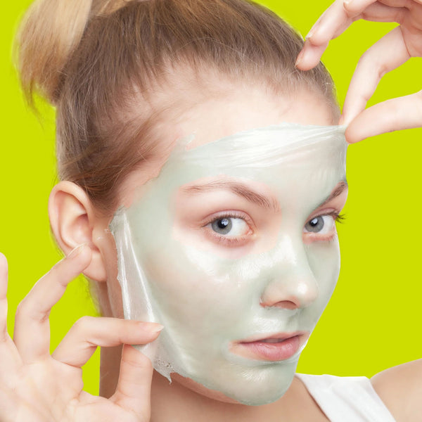Cucumber peel-off gel mask applied to face, hands pulling mask edge