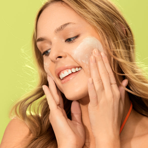 Facial cleanser and mask in use, creamy foam on face and hands