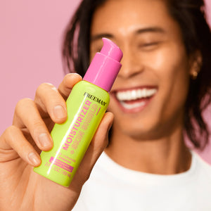 Hand holding green Moisturizer + Skin Shield bottle with pink pump